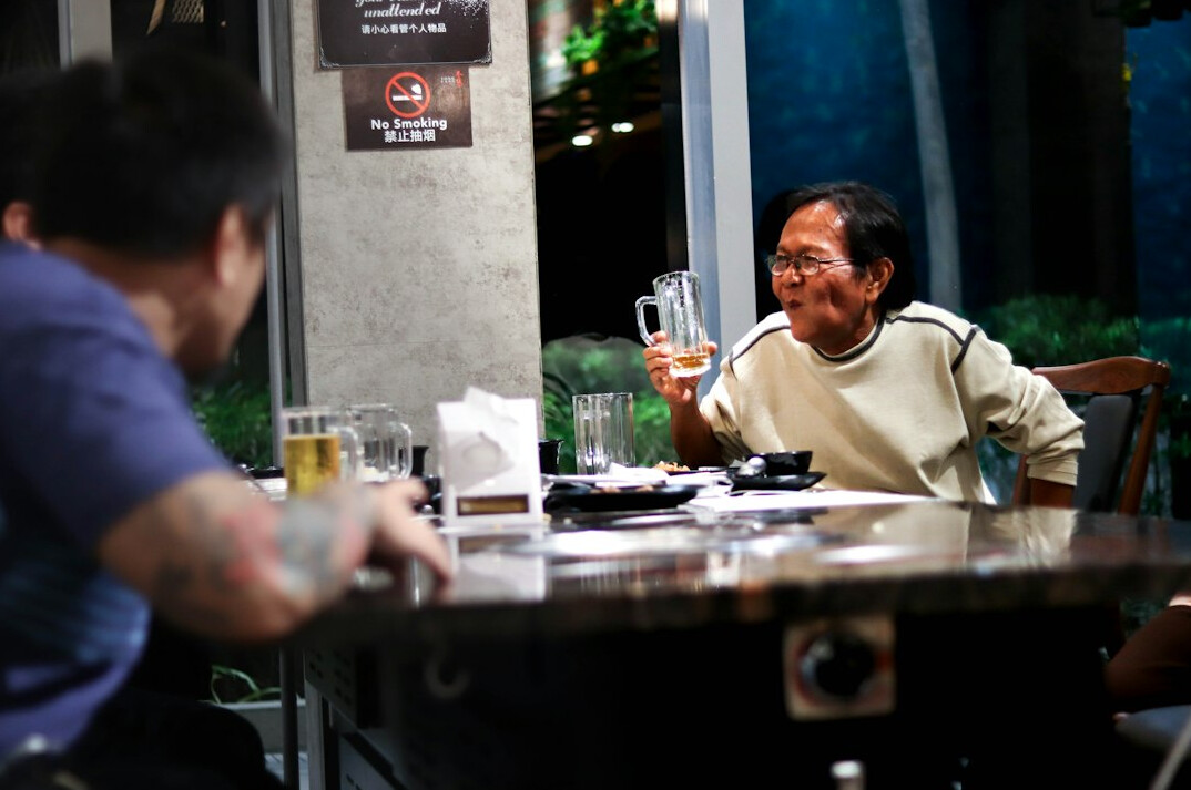 Two friends sharing a conversation and laughing at a small cafe table