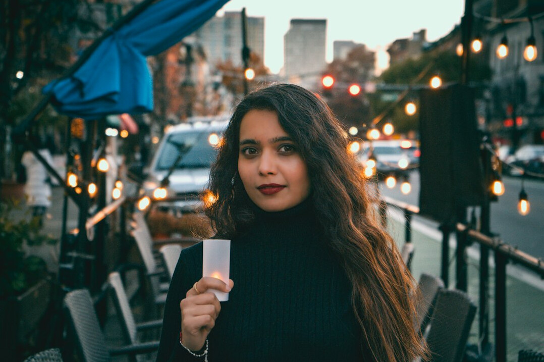 Portrait of a Chilean woman photographer with curly hair holding a camera